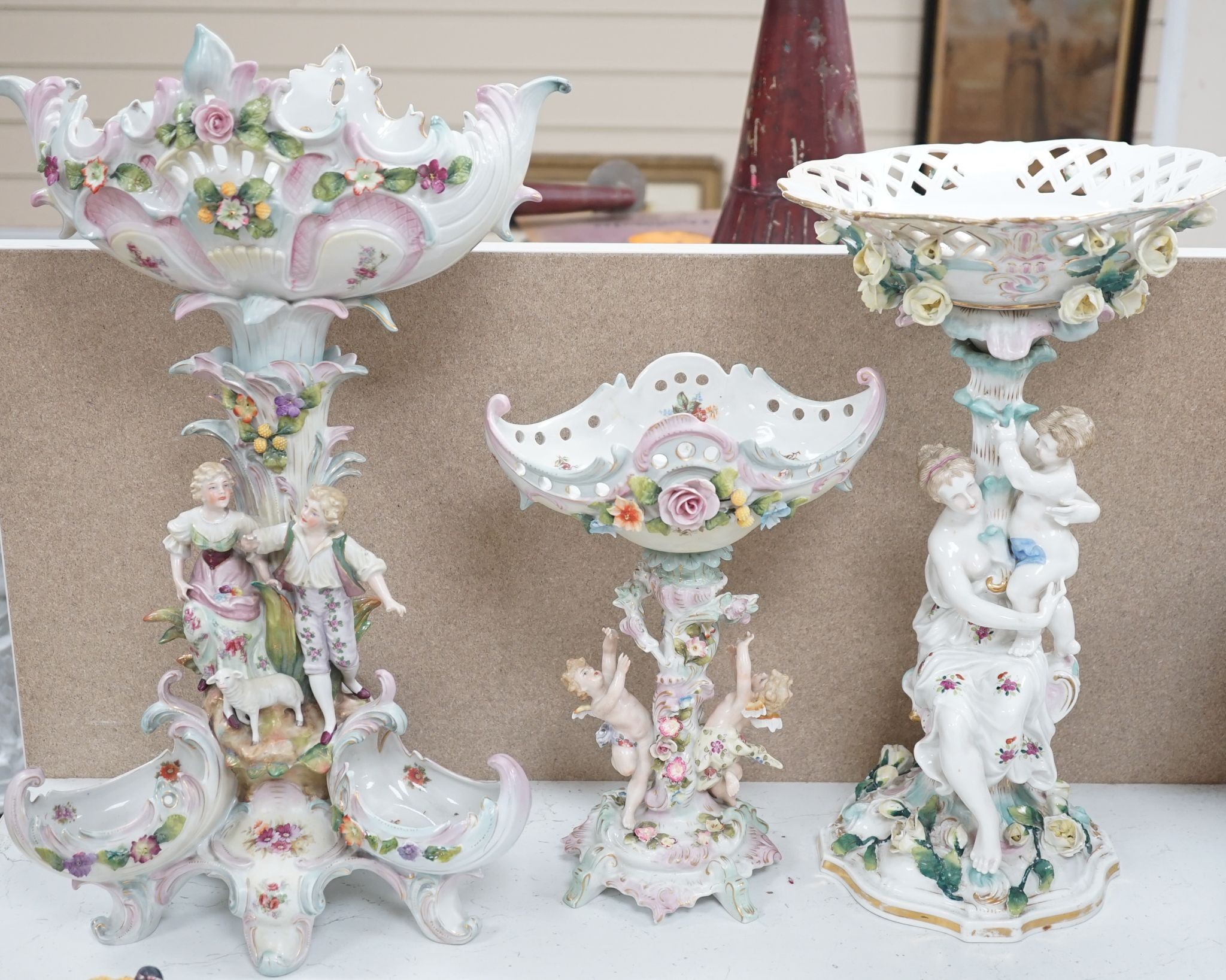 A tall German porcelain figural centrepiece bowl and two others smaller. Tallest 47cm